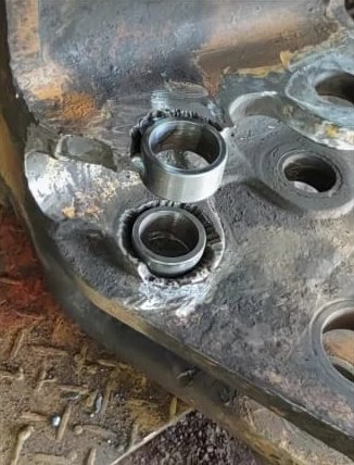 Buchas sendo instaladas e soldadas em uma peça de máquina