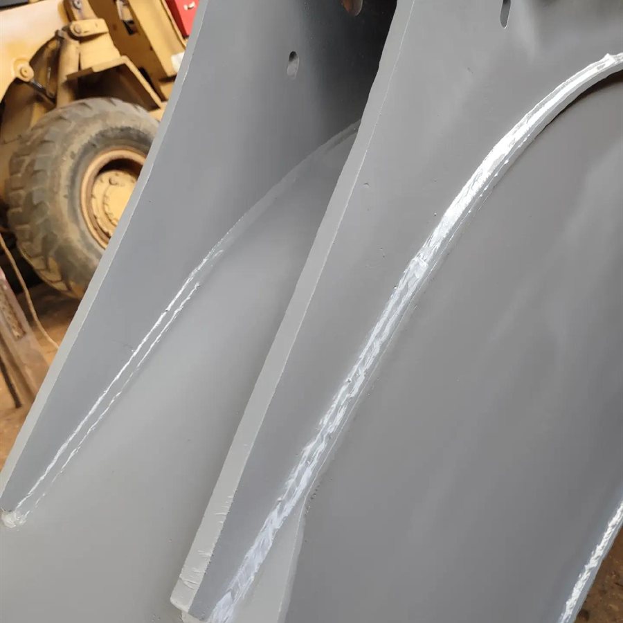 Detalhe dos cordões de solda na recuperação da lança John Deere, pintada de cinza