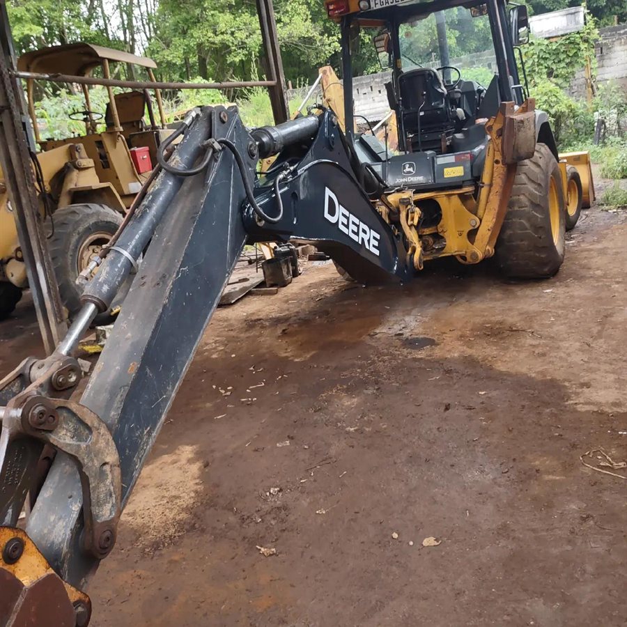 Retroescavadeira John Deere no pátio da oficina
